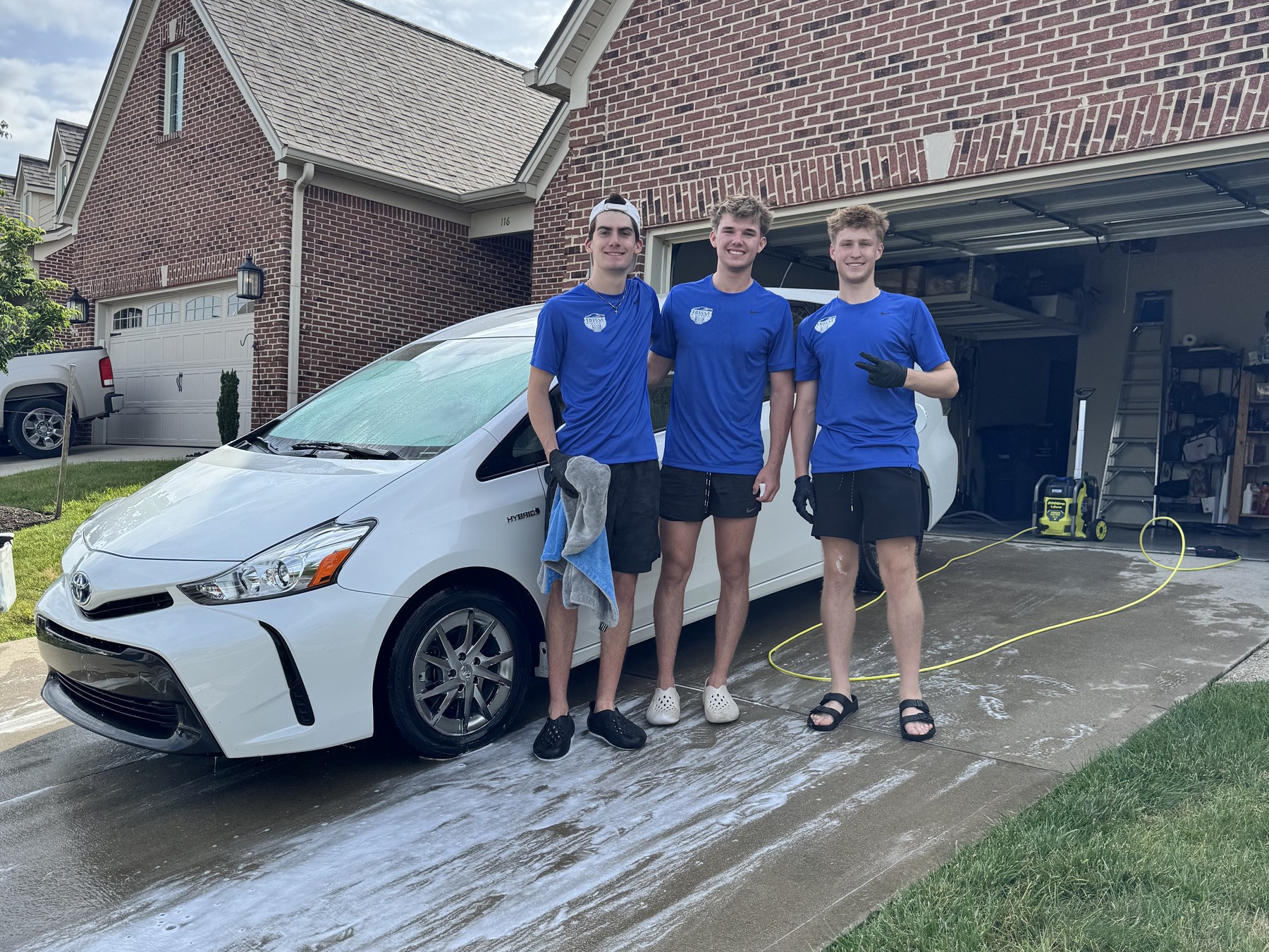 The Triple Threat Detailing team detailing a car in a driveway